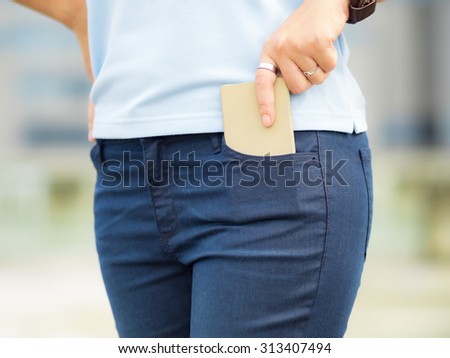 Smart phone in pocket of girl's trousers