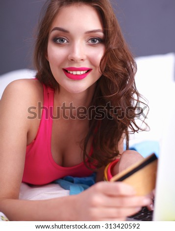 Pretty young woman sitting bed with shopping bags 