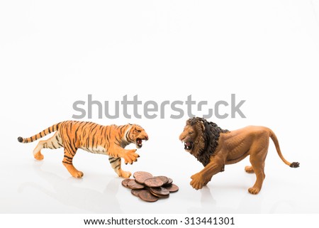 Photo shows the toy tiger lion and coins on white.