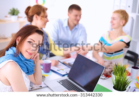 Portrait of attractive female  designer sittin on thesk  in office