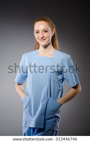 Young nurse against gray