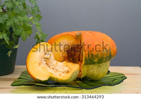 Organic fresh pumpkin squash over a wood table on natural environment.