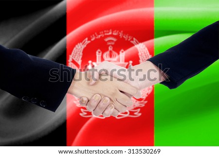 Two politicians shaking hands in front of afghanistan flag background