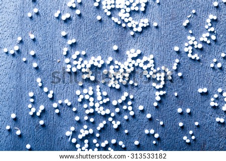 Pieces of foam plastic like snow balls on the background of the old wooden board table. Closeup. Toned.
