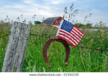 flag and horseshoe on farm fence