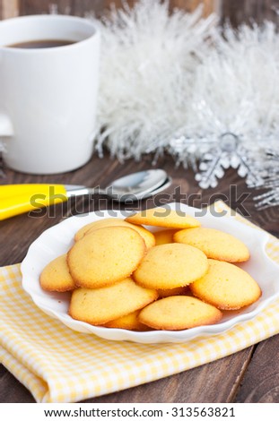 Corn cookies in a white plate on a yellow napkin next to a white tinsel