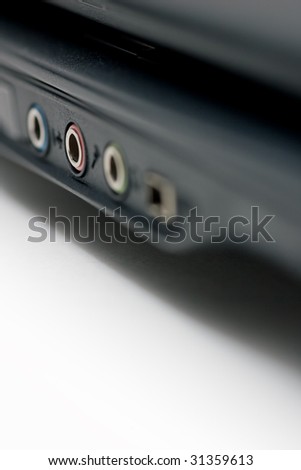 Closeup of notebook audio ports, showing the blue, pink and green inputs, as well as the firewire port.