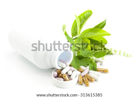 Herb capsule with green herbal leaf and bottle on white background. Royalty-Free Stock Photo #313615385