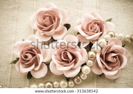 Vintage pink rose and Pearl Necklace on fabric background. Love concept.