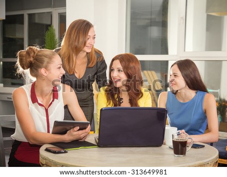 Working days in the women's team. Four young women - office staff. Discussion of joint work on the project. Woman business. Women working in the office at the computer. Group of women. Toned image.