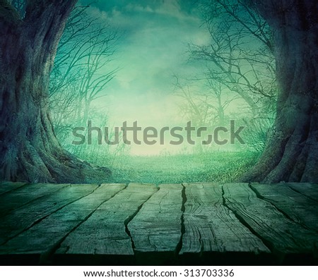 Halloween background. Spooky forest with dead trees and wooden table. Wood table
