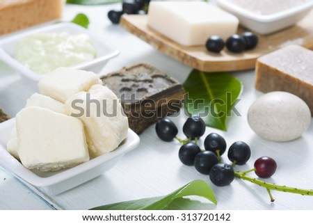 shea butter, soaps, henna blocks, sponge and moisturizer on white wood table 