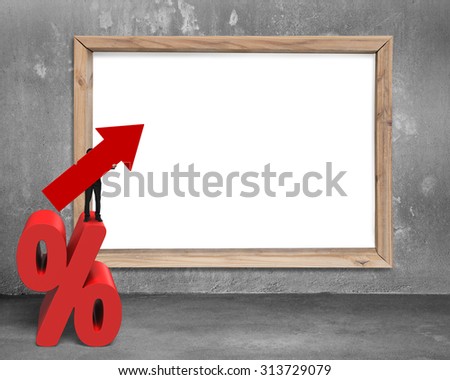 Businessman holding red arrow symbol standing on percentage sign, with blank white board on concrete wall.