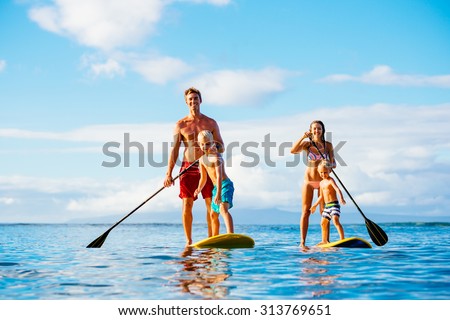 Family Having Fun Stand Up Paddling Together in the Ocean on Beautiful Sunny Morning Royalty-Free Stock Photo #313769651