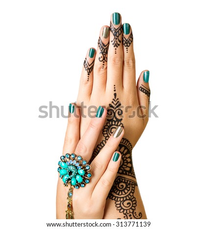Mehndi tattoo isolated on white. Woman Hands with black henna tattoos. Hands of Indian bride girl with mehndi and perfect emerald manicure and emerald Indian jewels. India national traditions