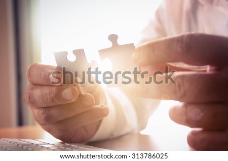 Business solutions, success and strategy concept. Businessman hand connecting jigsaw puzzle.  Royalty-Free Stock Photo #313786025
