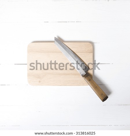knife and cutting board on white table