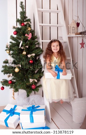 Little girl with gifts near the Christmas tree. Christmas, x-mas, winter, happiness concept