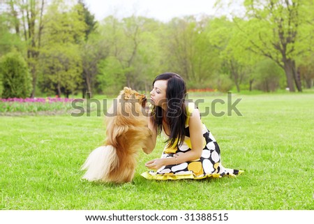 The image of a girl playing with a small dog in the park