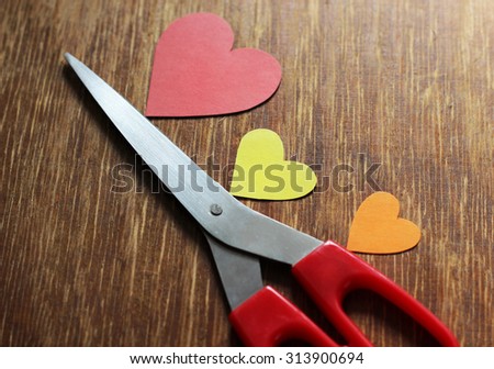 scissors and  three hearts on wood background