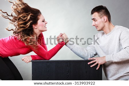 Partnership relationship concept. Girlfriend confronts his boyfriend. Woman and man arm wrestling challenge between young couple Royalty-Free Stock Photo #313903922