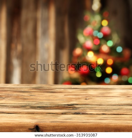 blurred background of xmas tree lights and wall with vintage table 