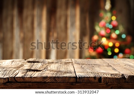 blurred wall background with xmas tree of few colors lights and shabby table 