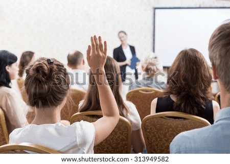 Photo of listener raising hand to ask question during seminar Royalty-Free Stock Photo #313949582
