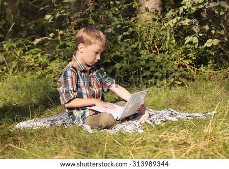 boy in nature with laptop
