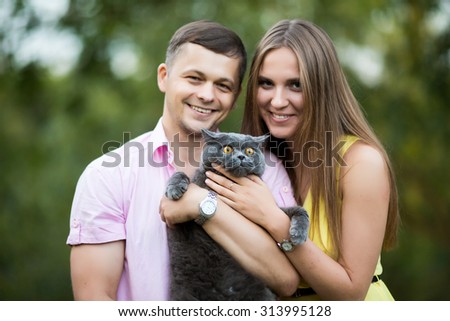 man and woman holding a cat