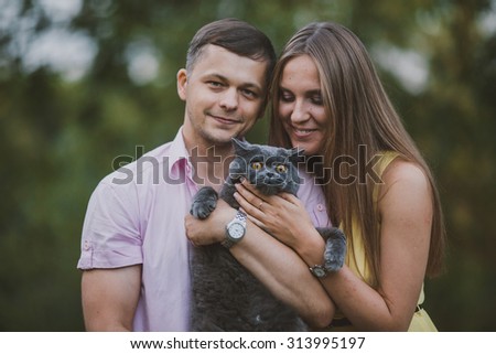 man and woman holding a cat