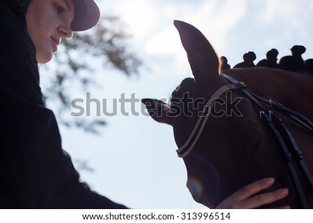 Close up of women jockey rider and horse outdoor. Portrait