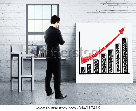 businessman looking at growth chart on desk