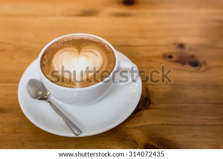 Hot art Latte Coffee in a cup on wooden table