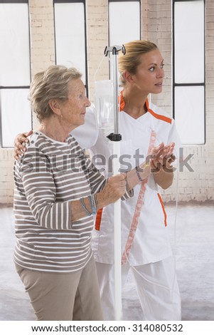 Nurse walking next to a patient with IV drip