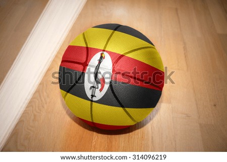 basketball ball with the national flag of uganda lying on the floor near the white line