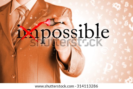 Businessman Hand turning the word Impossible into Possible with red marker 