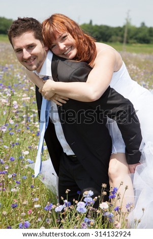 Newly lovely wedding couple happy in the country piggy back