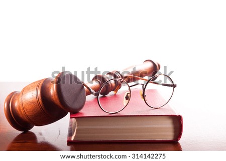 Gavel, book and glasses in a circular frame on a white background