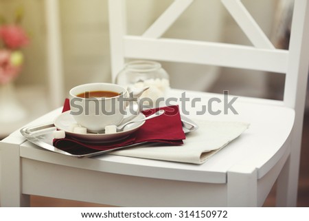 Cup of tea on chair in room