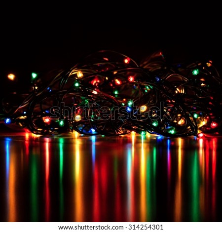 Abstract christmas lights on a tree with a beautiful reflection and black background