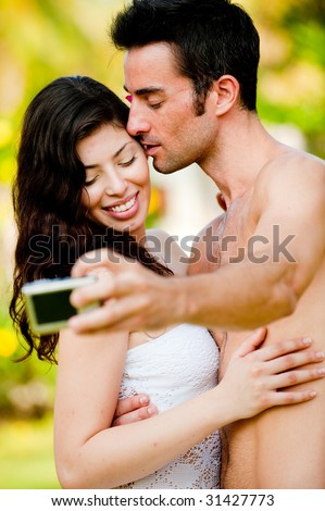 A couple taking photographs on vacation outdoors