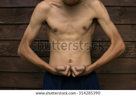 Slim Muscle man pretending to show the wooden floor backdrop. Royalty-Free Stock Photo #314285390