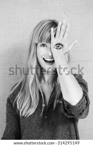 Surprised blond woman with painted eye