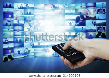 Big TV panel with television stream images and remote control in hand