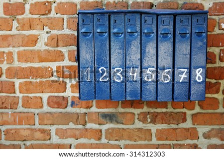Vintage blue mailbox on a brick wall