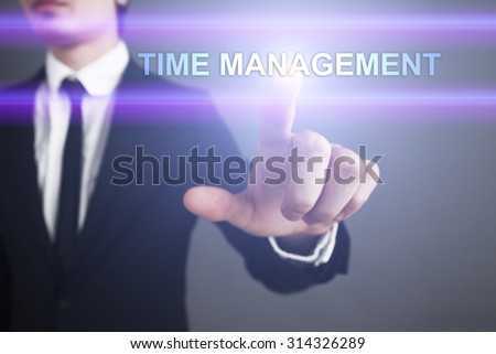 Businessman pressing touch screen interface and select "Time management". Business concept. Internet concept.