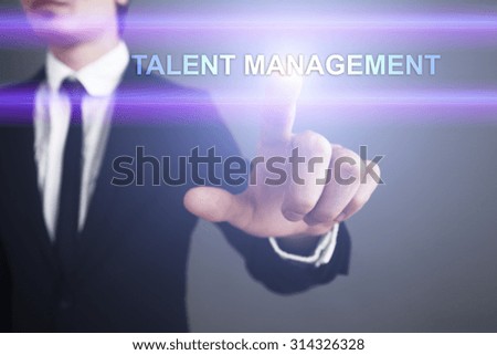 Businessman pressing touch screen interface and select "Talent management". Business concept. Internet concept.