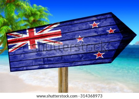 New Zealand Flag wooden sign on beach background