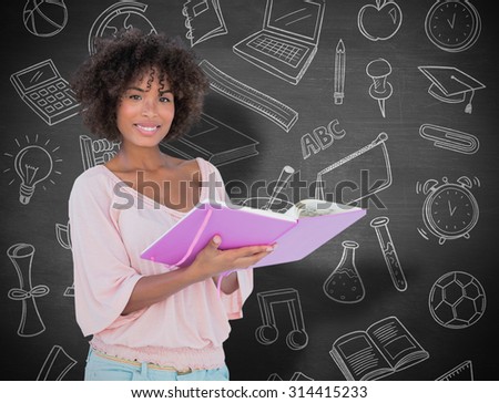 Beautiful woman holding photo album and smiling against black background